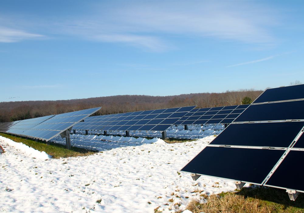 Ground-mount solar array in winter with snow on the ground at Carrier Clinic